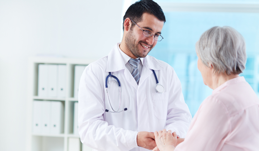 Healthcare CRM System - A young doctor assisting an older patient 